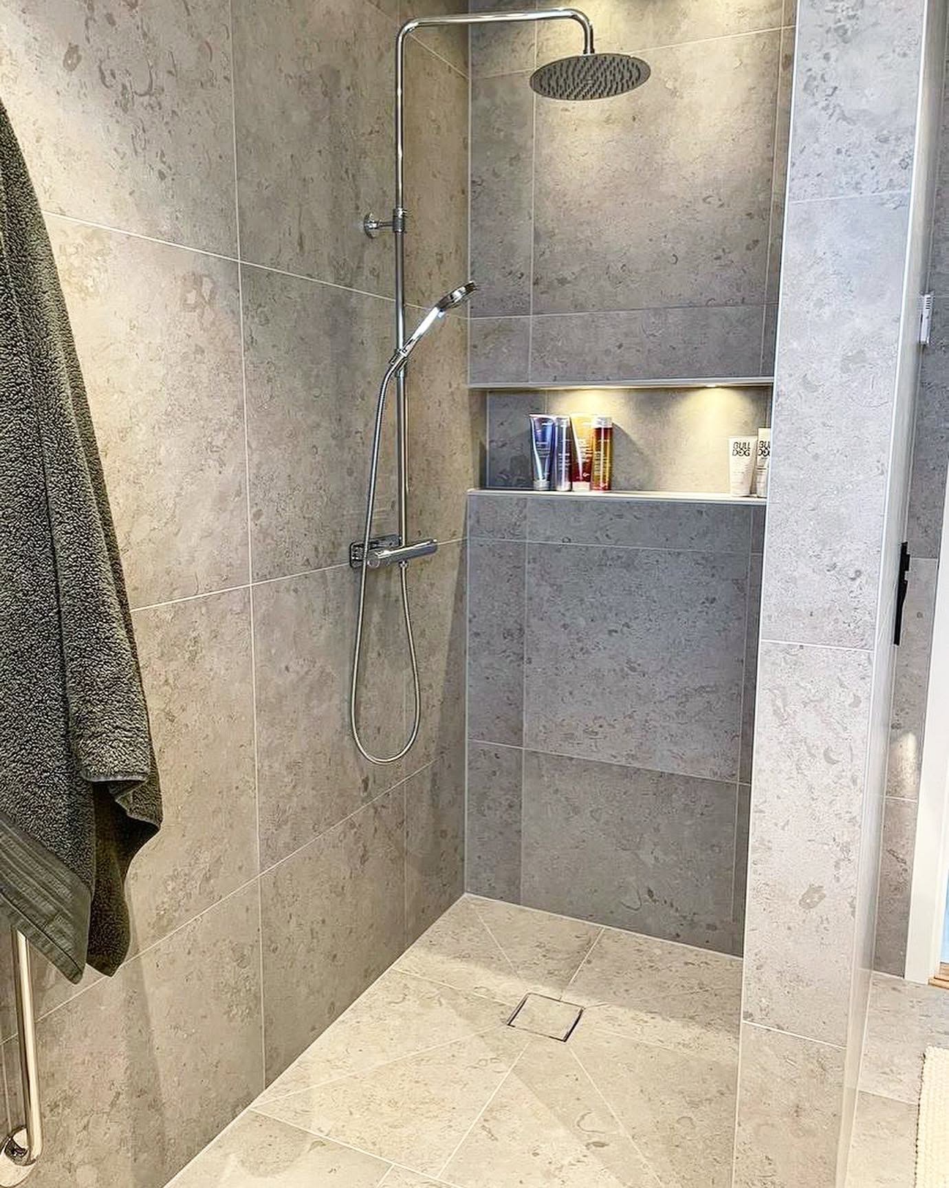 Dusch med nisch och grå kaklade ytor