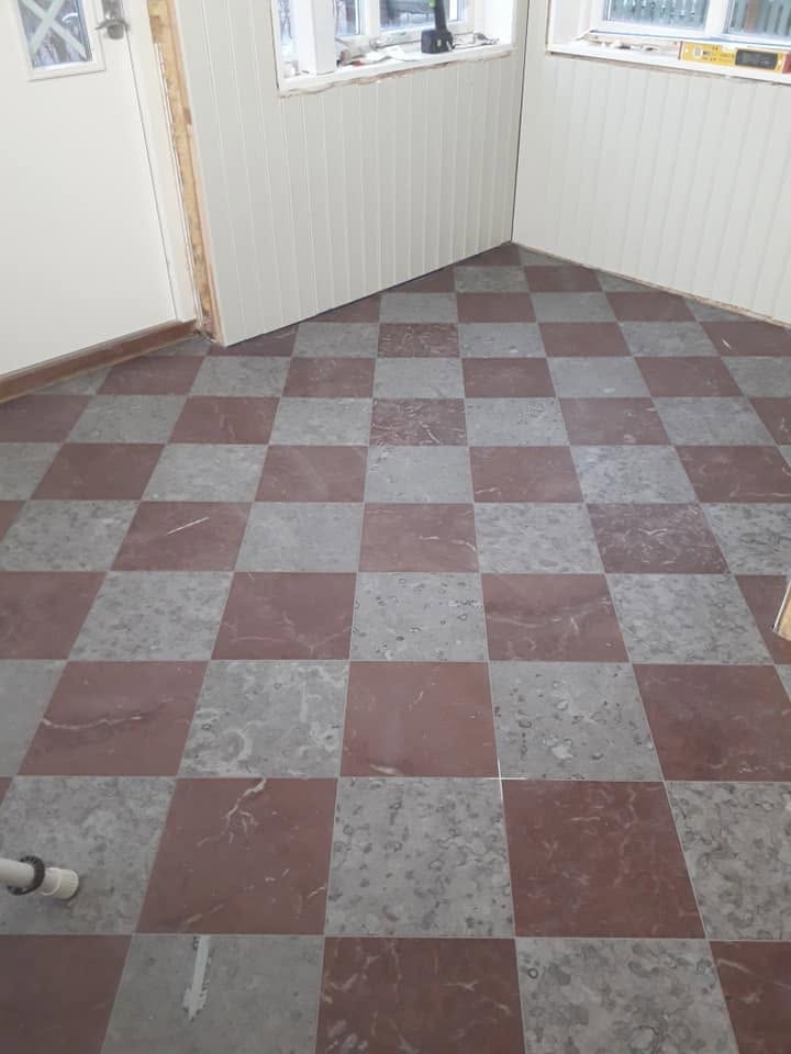Rutlagt golv med röda och grå naturstensplattor